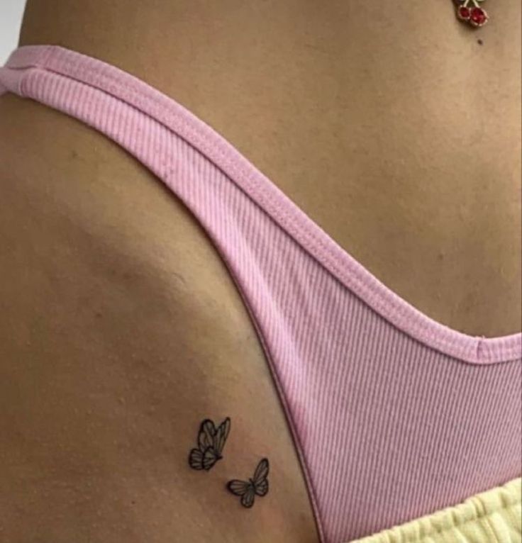 the back of a woman's stomach with two butterflies on her left side tattoo