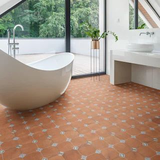 a bathroom with a large bathtub next to a sink under a slanted roof