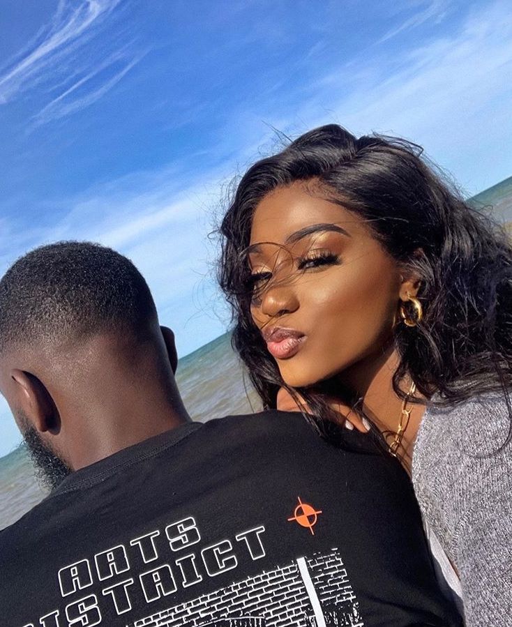 a man and woman standing next to each other on the beach