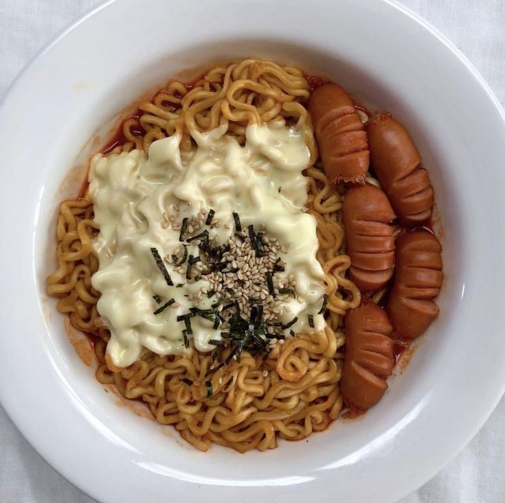 two hot dogs and noodles in a white bowl