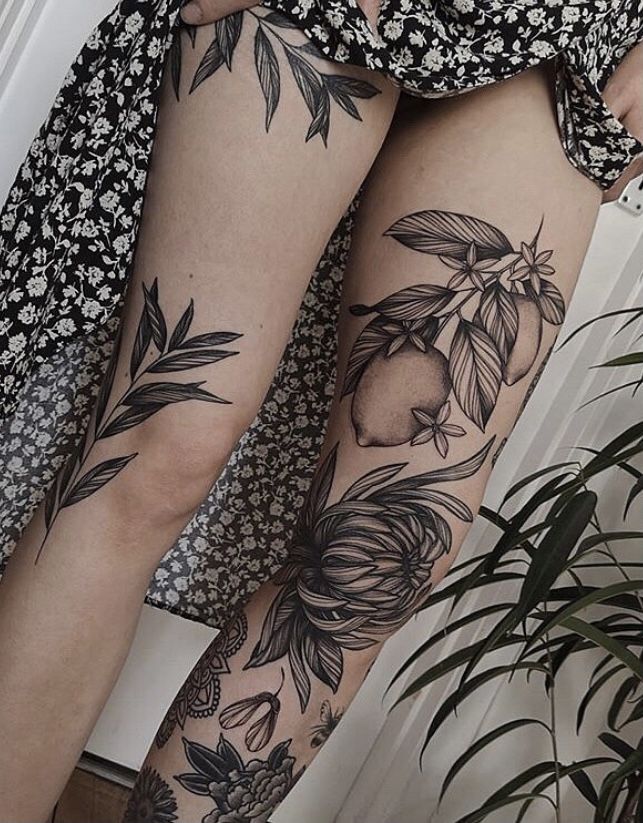 a woman's legs with tattoos and flowers on them