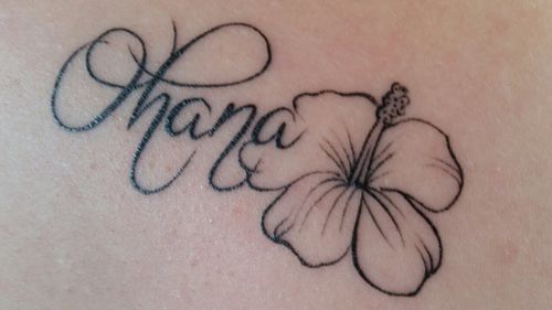 a tattoo on the back of a woman's shoulder that says, hope with a flower