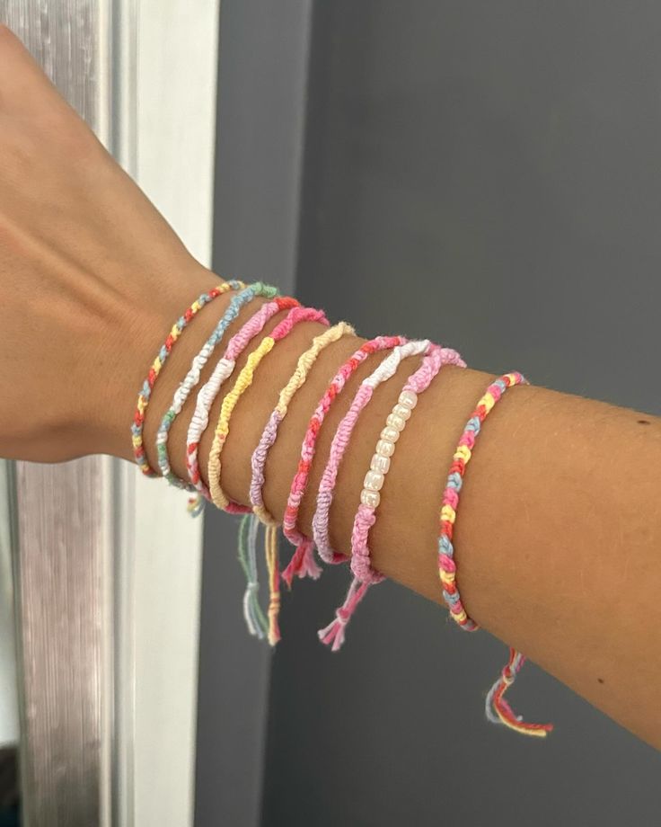 a woman's arm with several bracelets on it and a door in the background