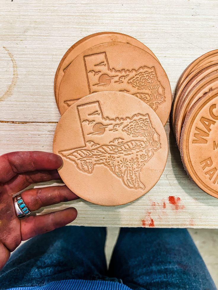 a person is holding four wooden discs with the words, i love my state on them