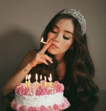 a woman is blowing out candles on her birthday cake