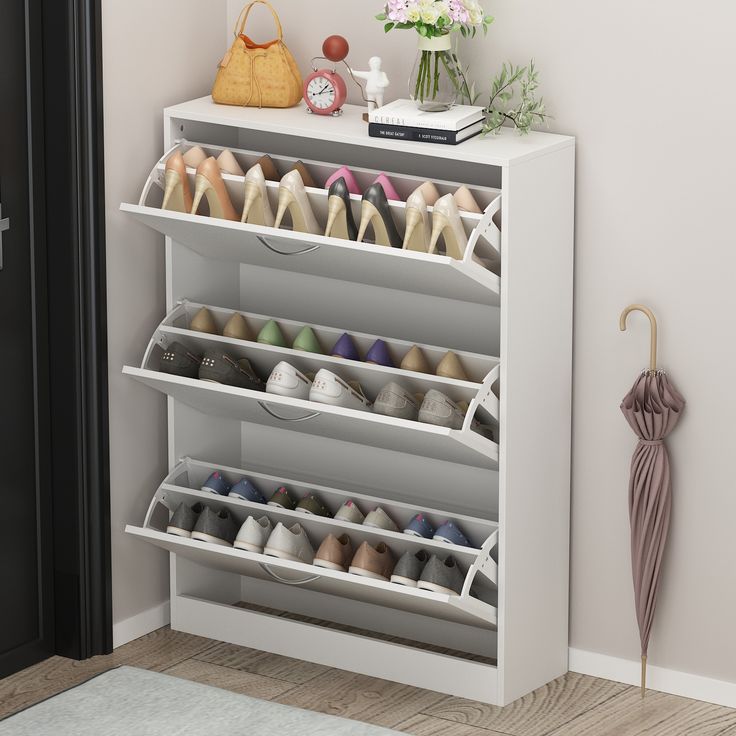 Create a clutter-free space for shoes or accessories with this clean-lined storage cabinet. Ideal for an entryway or living room, this cabinet features three drop-down drawers that open to reveal room for up to 18 of your favorite flats, sneakers, and heels. The freestanding frame is made from solid and engineered wood with a clean white finish that's scratch-free, and it rests on a plinth-style base for a complete the look. Plus, the surface on this cabinet is great for displaying accent pieces Flip Door, Narrow Shoe Rack, Shoe Rack Organization, Narrow Shoes, Entryway Bedroom, Streamlined Design, Shoe Storage Cabinet, Shoe Organizer, Mirror Designs