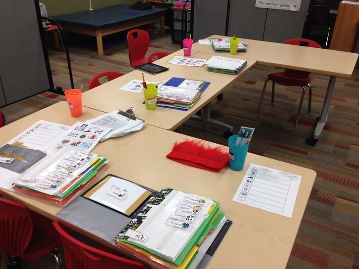 several desks with books and binders on them in an office setting for students to study