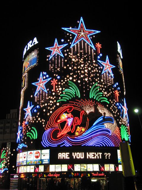 the building has many lights on it and is lit up at night with stars in the sky