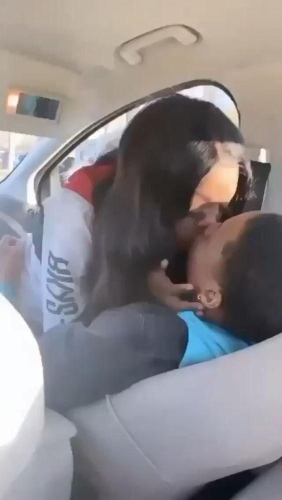 a man and woman kissing in the back seat of a car