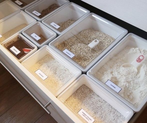 several bins filled with different types of birdseed on top of a wooden floor