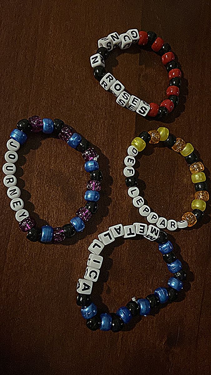 three bracelets with words written on them sitting on a table next to each other