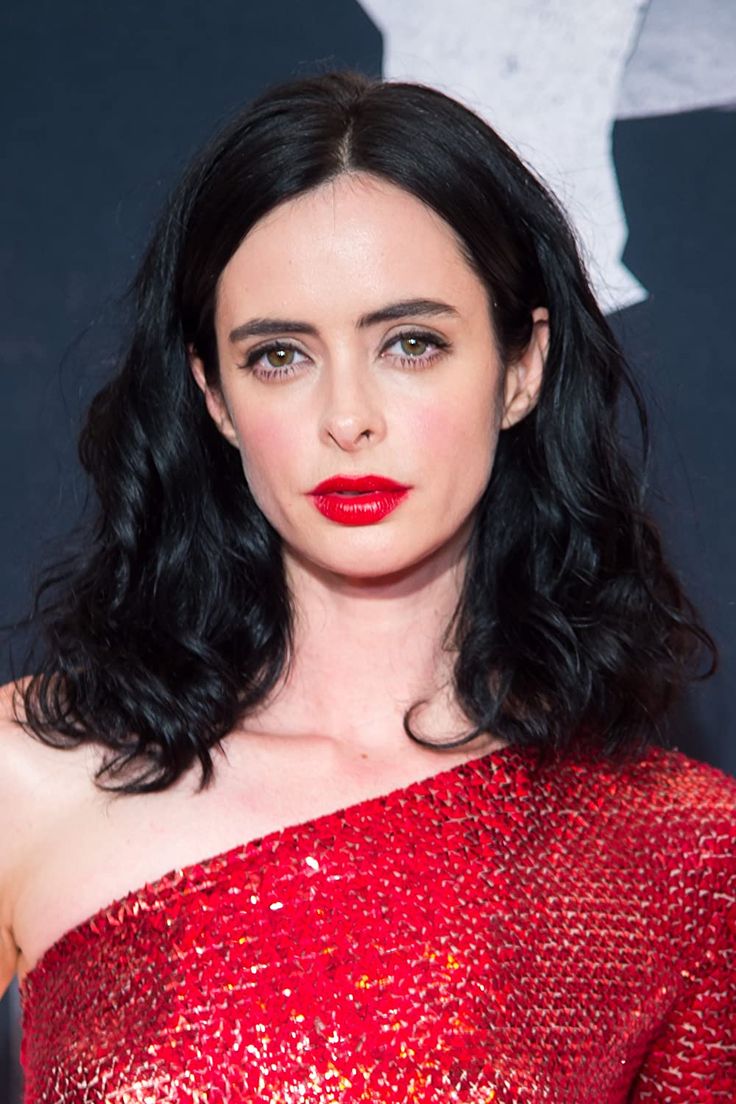 a woman with long black hair wearing a red dress