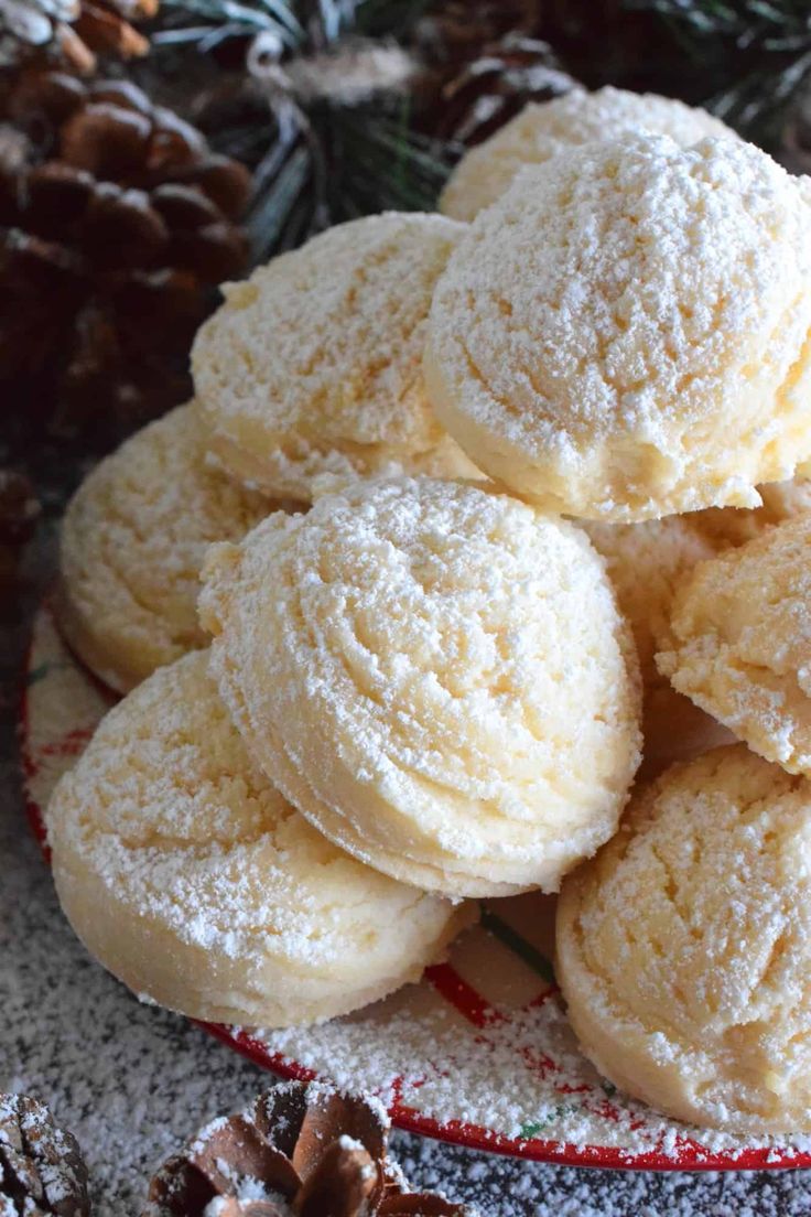 a pile of powdered sugar cookies sitting on top of a red and white plate