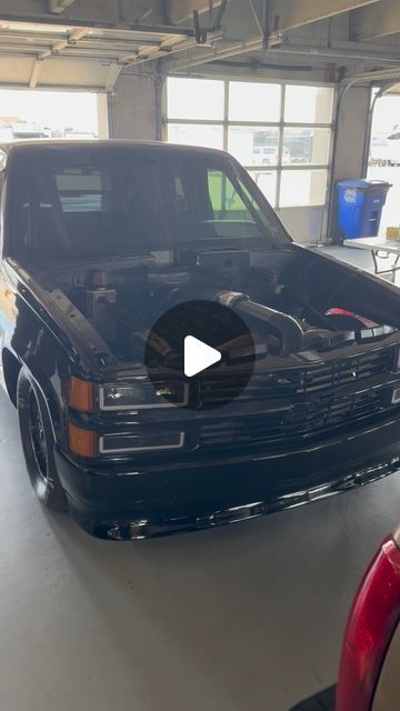 a truck parked in a garage with the hood up and it's hood open