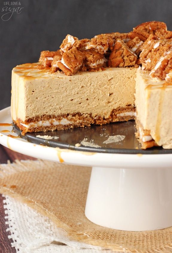 a cheesecake on a cake plate with one slice cut out and ready to be eaten