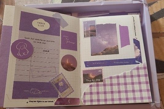 an open purple box with pictures and papers inside