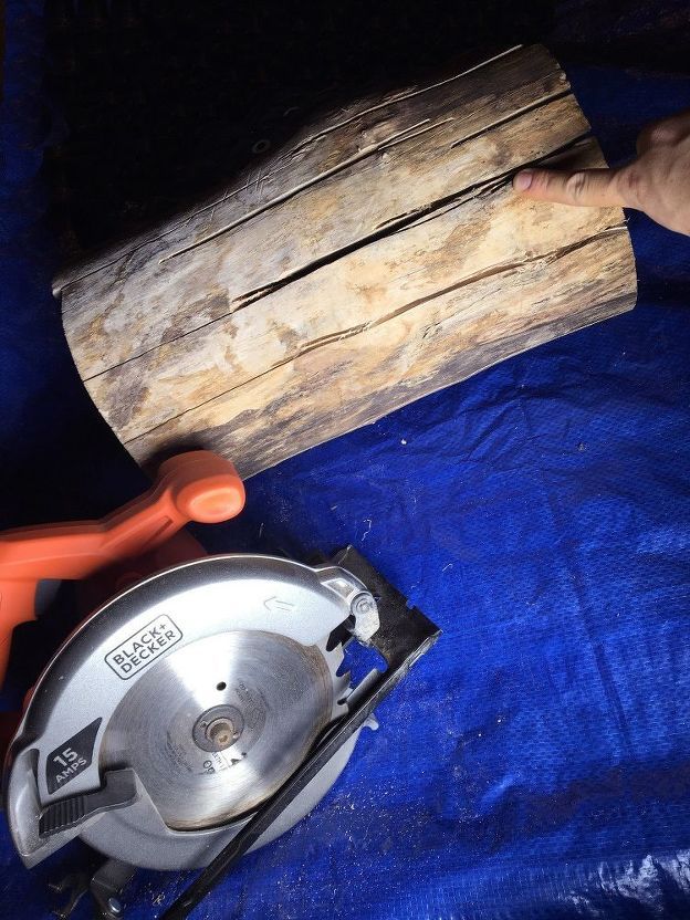 a person holding a circular saw next to a piece of wood on a blue tarp