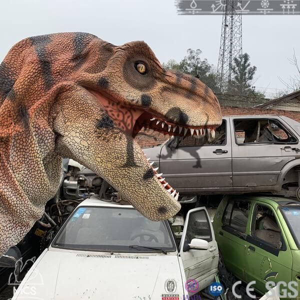 an inflatable t - rex standing next to a car and truck with it's mouth open