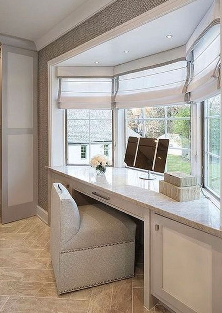 a desk with a chair in front of it and a large window behind the desk