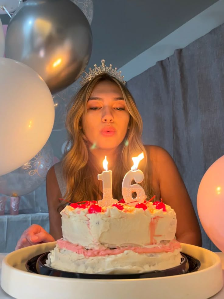 a woman blowing out the candles on her birthday cake