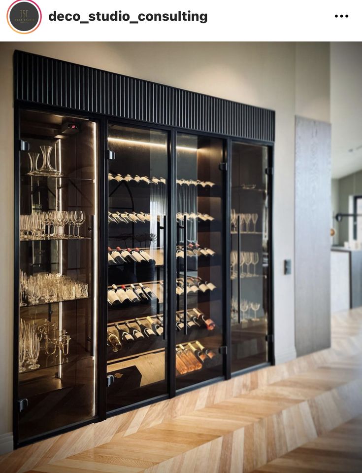 a wine cellar with glass doors and shelves full of glasses on the wall, next to a wooden floor