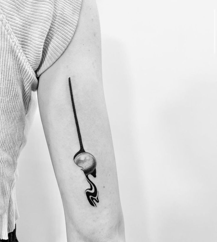 a black and white photo of a person's arm with a tattoo on it