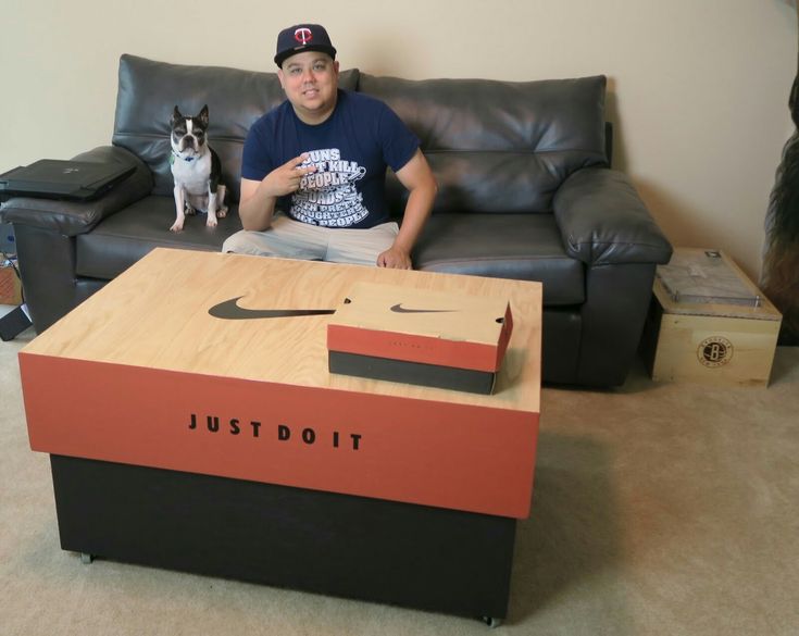 a man sitting on a couch next to a table with a dog in front of it