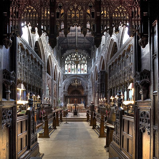 the inside of a large cathedral with pews and stained glass windows on both sides