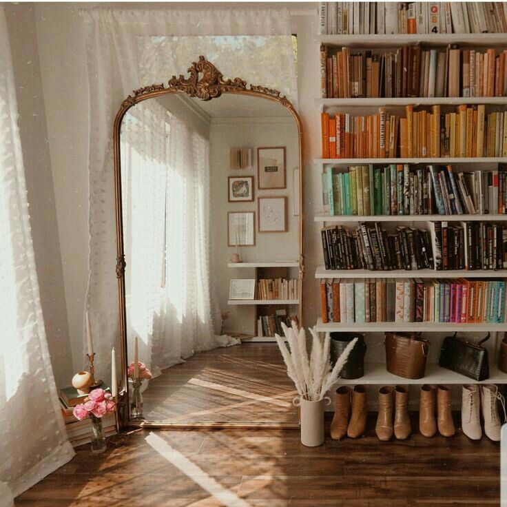 a bookshelf filled with lots of books next to a window