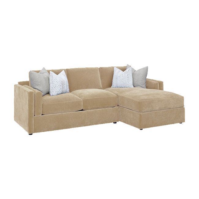 a large sectional couch with pillows on it's back and two sides facing each other