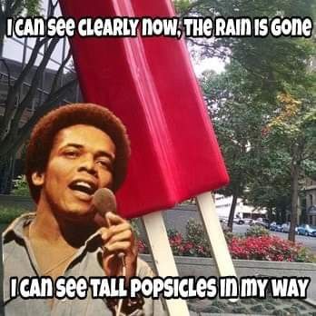 a man holding a microphone and standing in front of a giant red sign that says i can see clearly now, the rain is gone