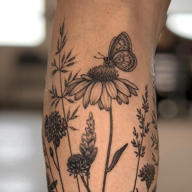 a woman's leg with flowers and a butterfly on it