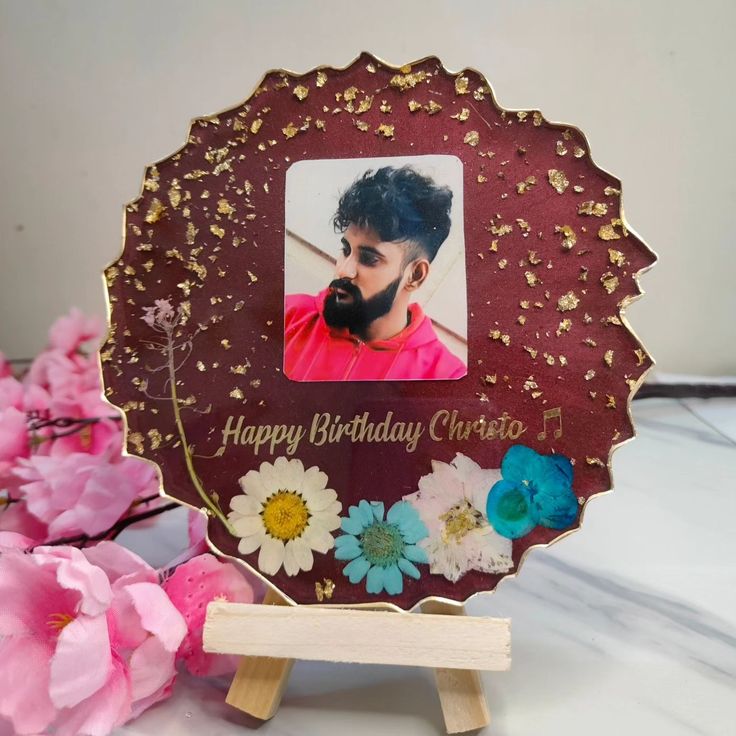 a happy birthday card with flowers and a wooden stand for it to hold the photo