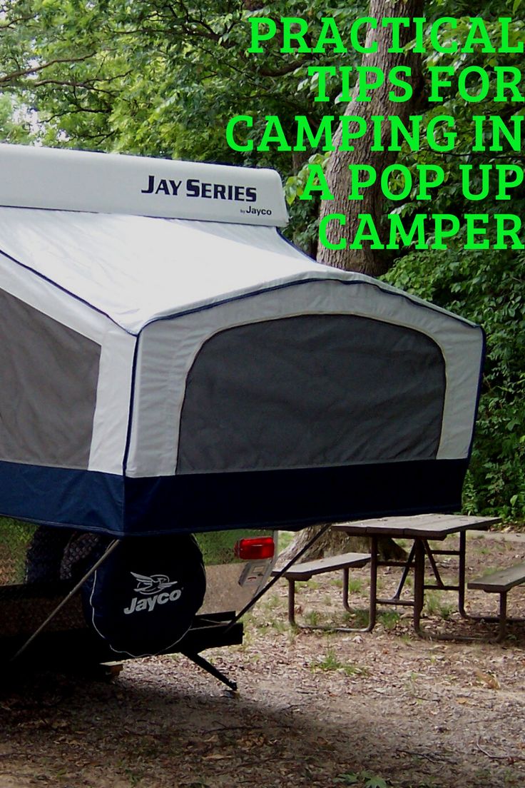 a camper trailer parked in the woods with text overlay that reads, practical tips for camping in a pop up camper