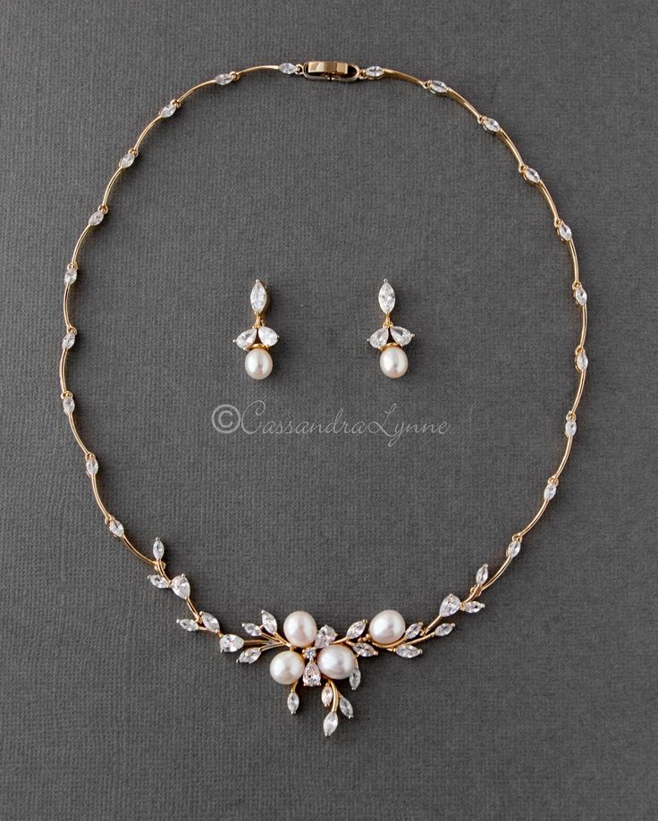 a necklace and earring set with pearls on a gray background, the jewelry is made out of gold plating