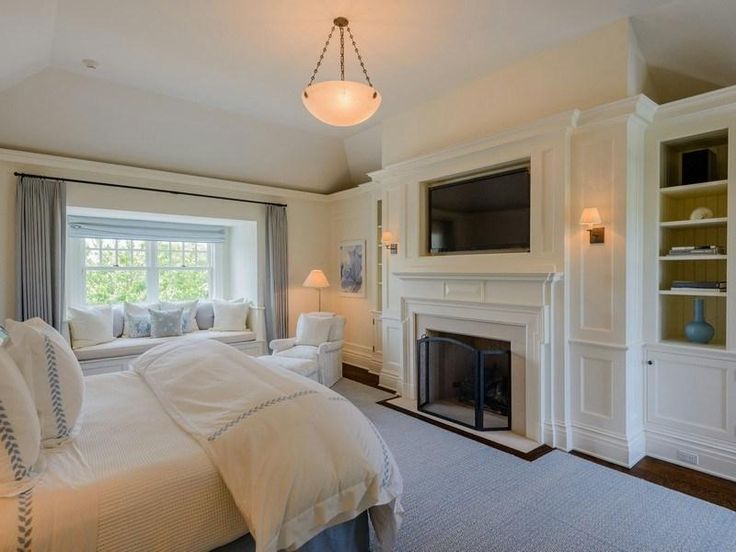 a large bedroom with a fireplace and built in bookshelves