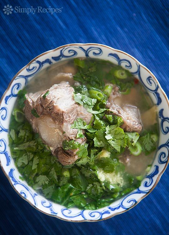 an image of a bowl of food with broccoli and meat in it on a blue table cloth