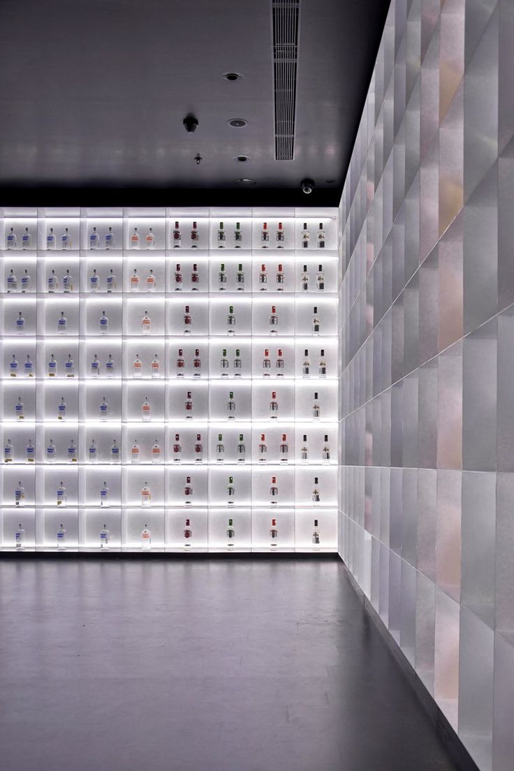 an empty room with rows of glass shelves on the wall and lights in the ceiling