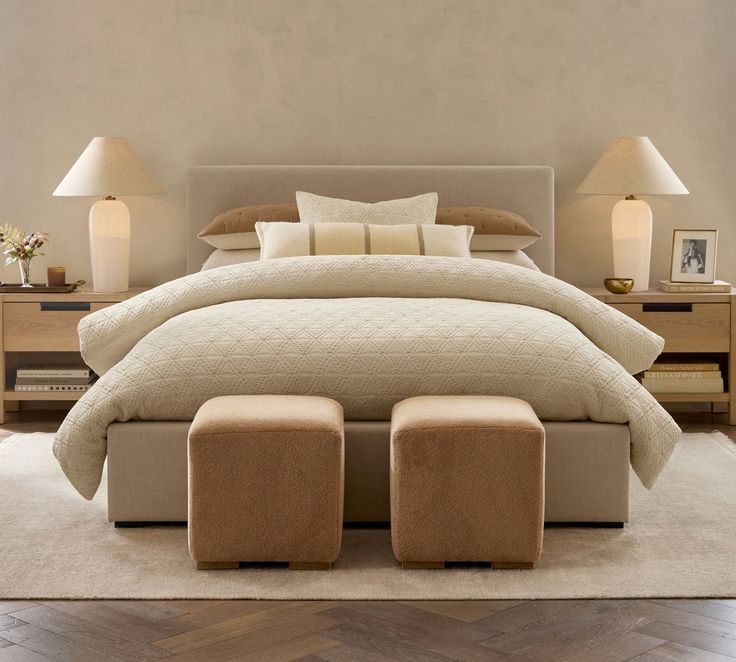 a large bed with two foot stools in front of it