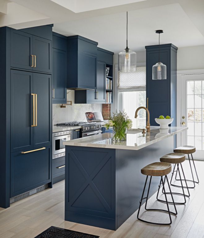 a kitchen with blue cabinets and stools next to an island in the middle of the room