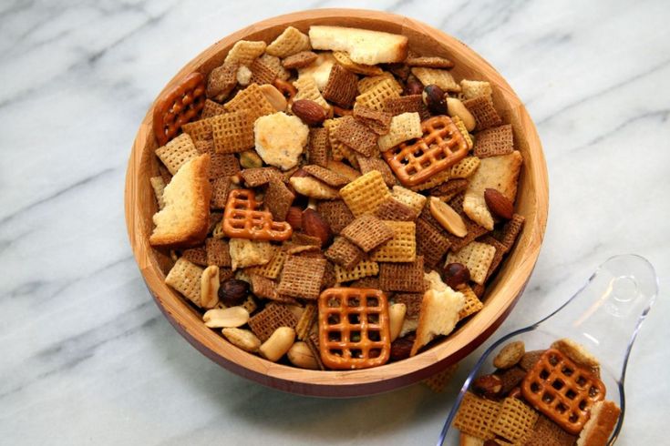 a bowl filled with cereal and pretzels on top of a white countertop