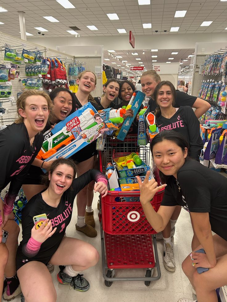 a group of young women standing next to each other in front of a shopping cart