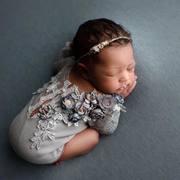 a baby is sleeping on the floor with her head tucked under her hands and eyes closed