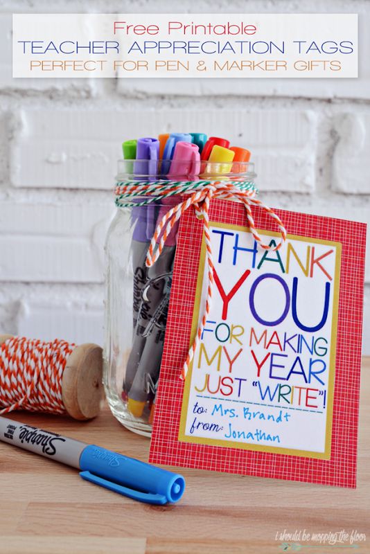 a jar filled with crayon markers next to a thank you sign and some twine