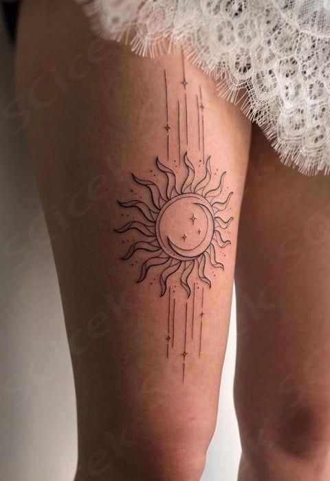 a woman's thigh with the sun and stars tattoo on her leg, in black ink