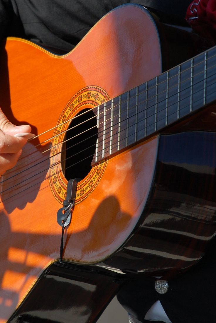 a person is playing an acoustic guitar outside