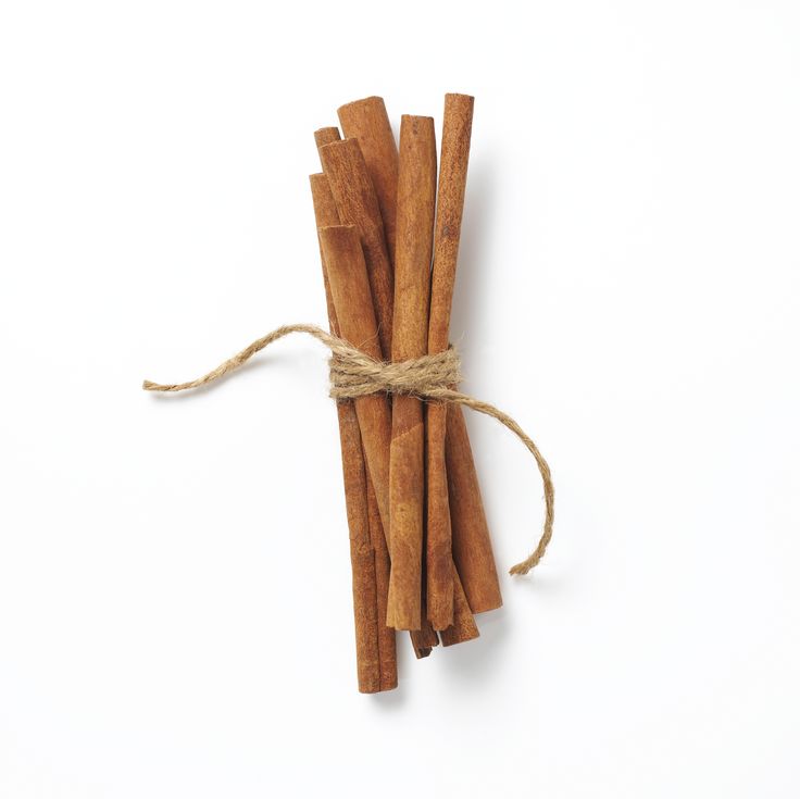 cinnamon sticks tied with twine on white background