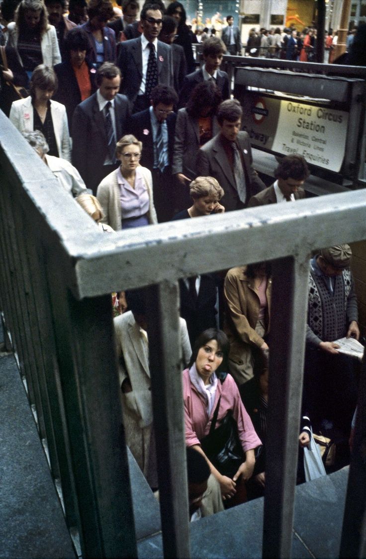 a group of people standing on the side of a train platform next to each other