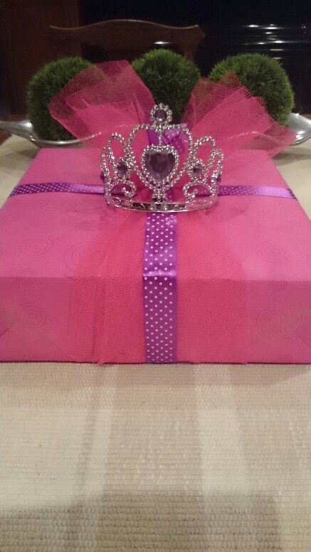 a pink present box with a tiara on top