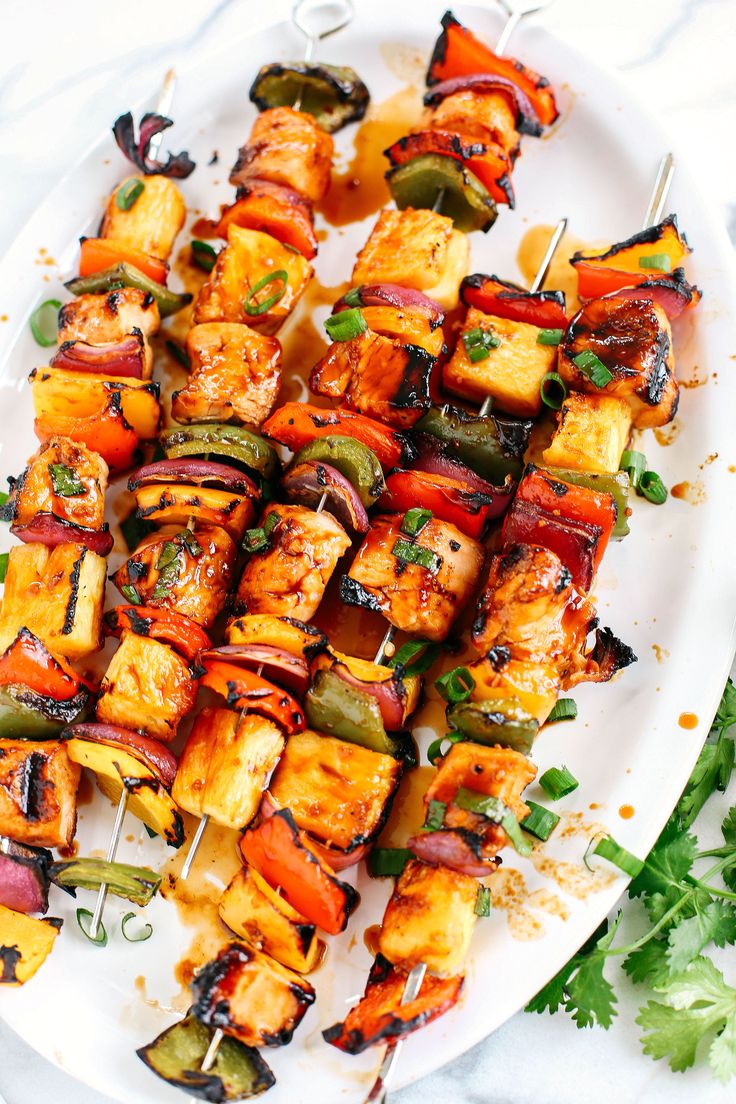 chicken and vegetable kabobs on a white plate